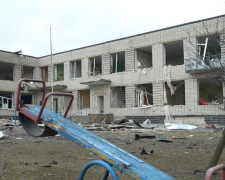 Дитяча гойдалка на фоні пошкодженого садочка у Біленькому Запорізької області, березень 2026 року. Фото "Суспільне" 