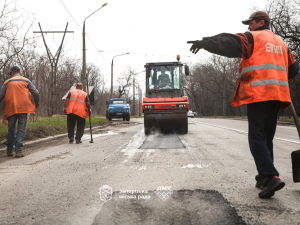 У Запоріжжі зима була нещадна до асфальту: на Хортиці латають стратегічний шлях від Мамая до аркового мосту (фото)