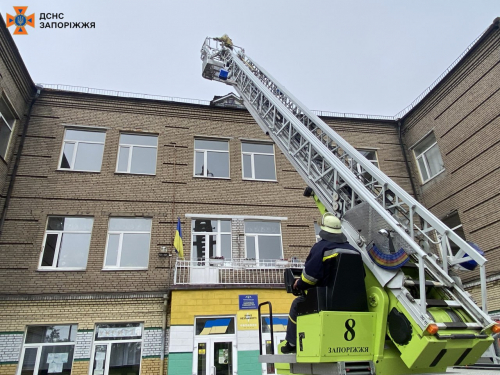 Міг впасти на голову - з даху запорізької гімназії небезпечно звисав металевий лист (фото)