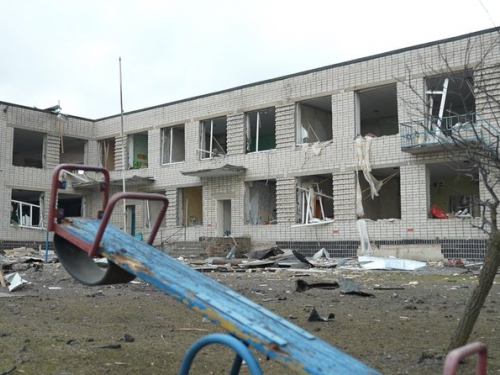 Дитяча гойдалка на фоні пошкодженого садочка у Біленькому Запорізької області, березень 2026 року. Фото "Суспільне" 