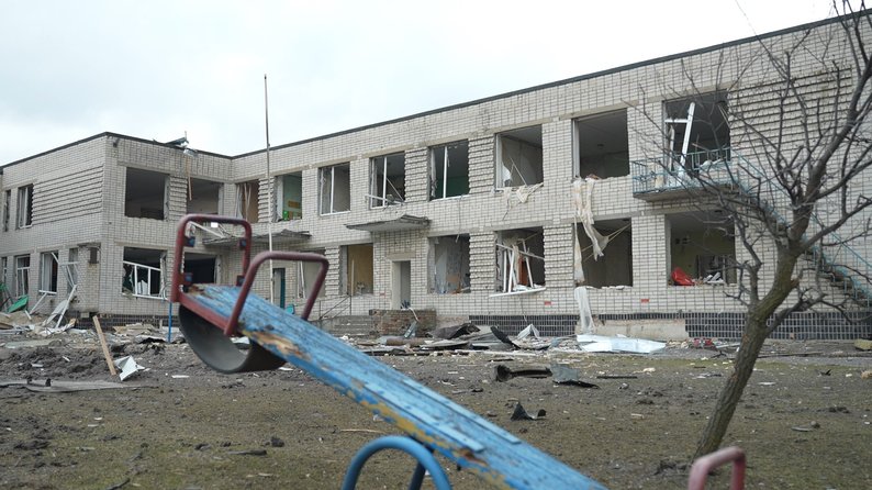 Дитяча гойдалка на фоні пошкодженого садочка у Біленькому Запорізької області, березень 2026 року. Фото "Суспільне" 